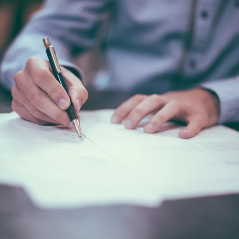 Person reviewing roofing contract documents to avoid scams